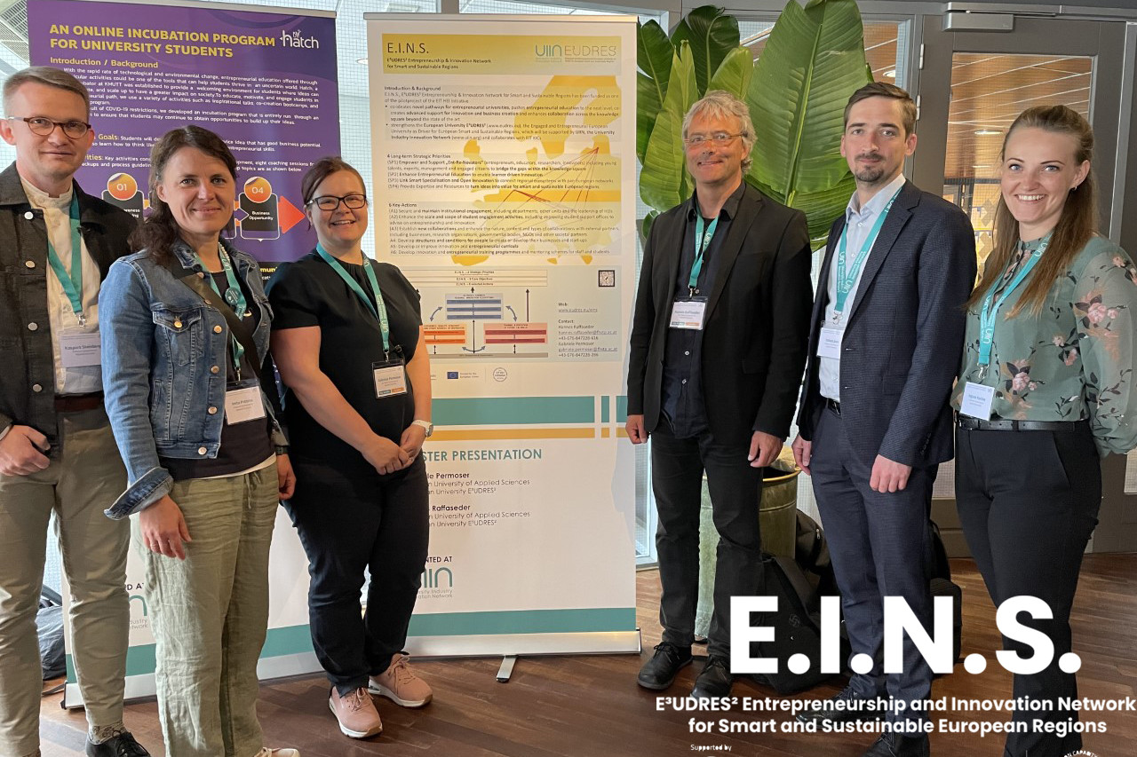 People walking through a bright indoor hallway with glass walls and shops.