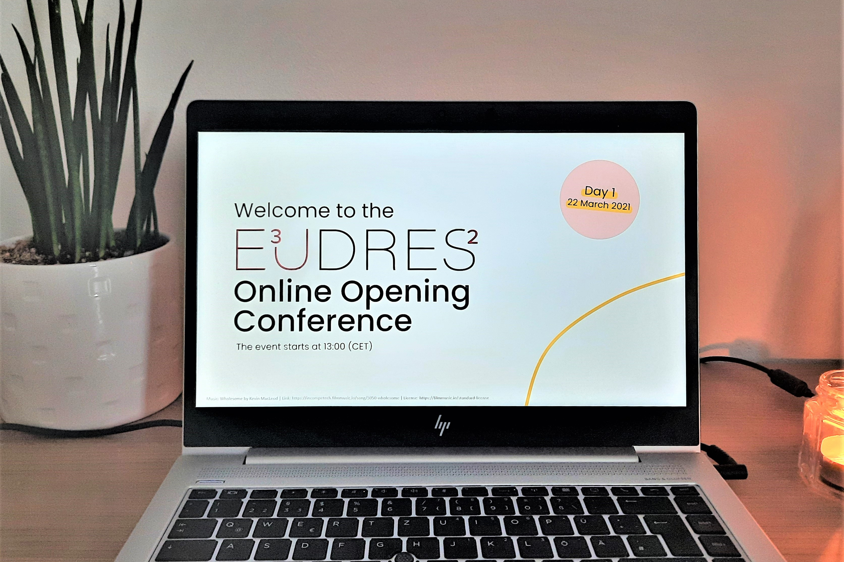 People walking through a bright indoor hallway with glass walls and shops.