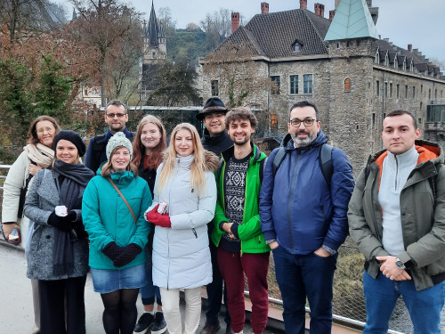 Group of people posing in front of a castle.