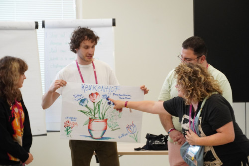 Participants of the Bootcamp presenting a poster with Dutch flowers drawn on it.
