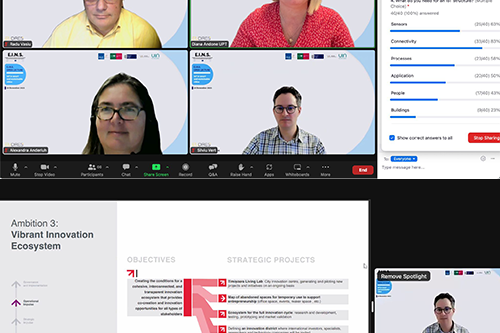 People walking through a bright indoor hallway with glass walls and shops.