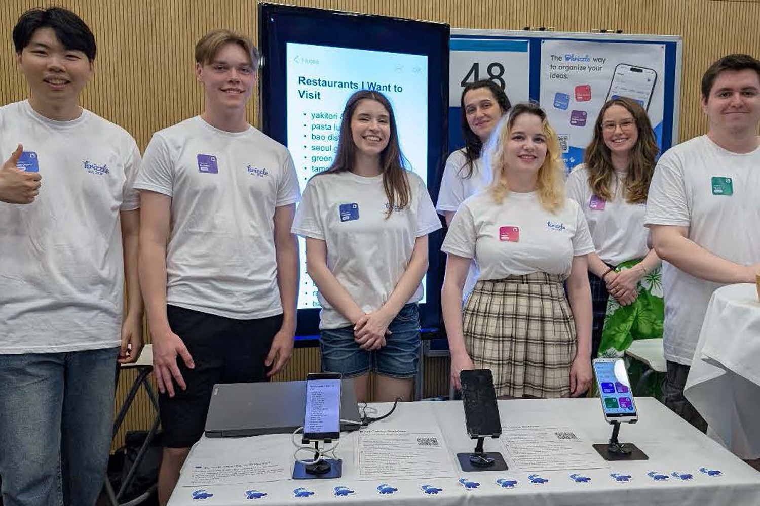 People walking through a bright indoor hallway with glass walls and shops.