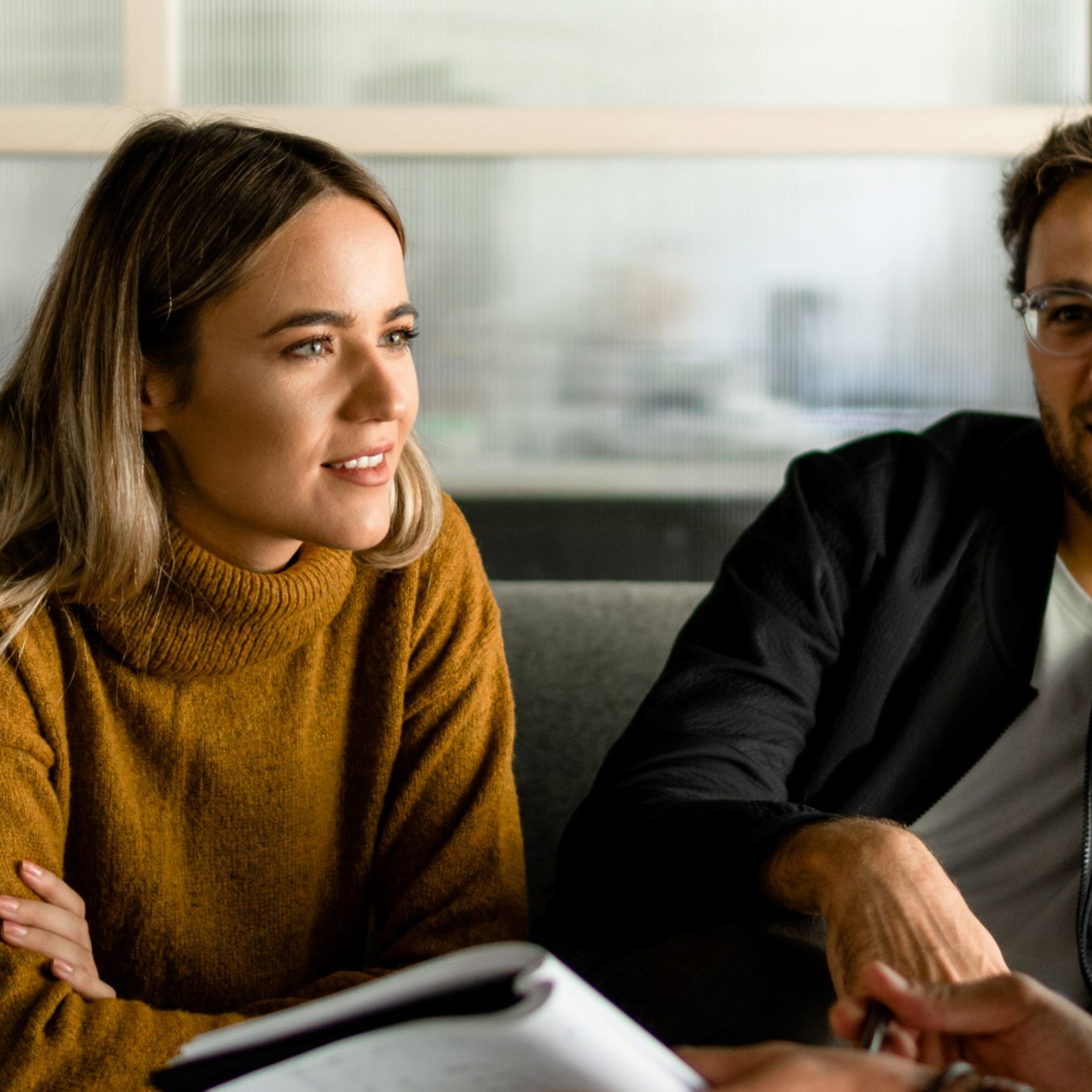 Photo of three people engaged in a meeting.